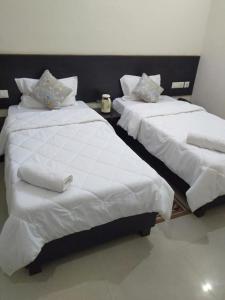 two beds sitting next to each other in a room at Hotel the Ideal in Kushinagar