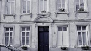 un edificio con una puerta y ventanas negras en sérénite normande, en Bolbec