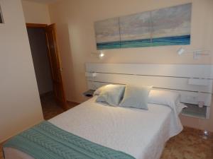 sypialnia z białym łóżkiem i dwiema poduszkami w obiekcie Gran terraza con espectaculares vistas al mar w mieście Cabo de Palos +33 zdjęcia