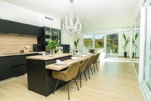 a kitchen with a long table with chairs and a chandelier at Villa Crystal in Rogaška Slatina