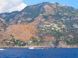a mountain with houses on top of it on the water at GIARDINO SUL MARE in Amalfi