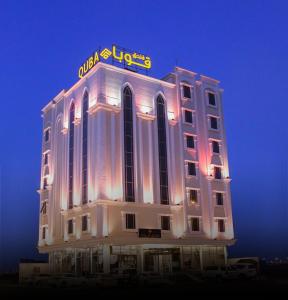 a building with a neon sign on top of it at Quba Inn Hotel in Jazan