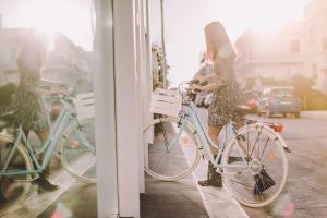 Uma mulher está ao lado de uma bicicleta numa loja. em Suite 10 Home Design & Spa em Polignano a Mare