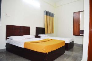 a bedroom with two beds in a room at Jippus Galaxy Budget Air port hotel in Cochin