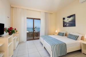 a bedroom with a bed and a view of the ocean at Indigo Mare in Platanias