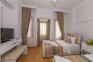 1 dormitorio con 1 cama y TV de pantalla plana en Rosalie Palace, en Estambul