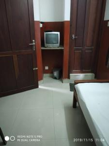 a bedroom with a bed and a tv in a room at UNNIKRISHNA LODGE in Cochin