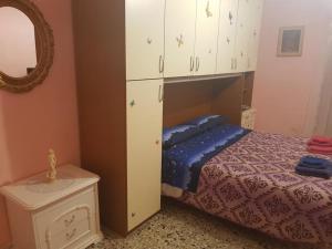 sypialnia z łóżkiem, lustrem i szafką w obiekcie Nel Cuore di Gaeta w mieście Gaeta