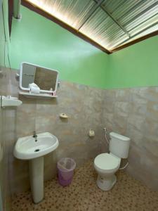 La salle de bains est pourvue de toilettes blanches et d'un lavabo. dans l'établissement Khaosok Bamboo Huts Resort, à Khao Sok
