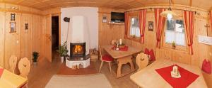 ein Wohnzimmer mit Kamin in einem winzigen Haus in der Unterkunft Schiestl's Landhaus in Mayrhofen