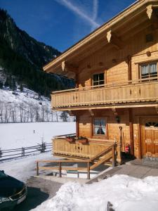 ein Blockhaus im Schnee mit einer Bank davor in der Unterkunft Schiestl's Landhaus in Mayrhofen