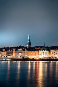 Una ciudad iluminada por la noche en el agua en Room at Stockholm - Sweden, en Estocolmo