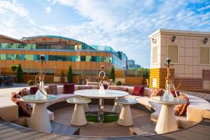 Ark Palace Hotel & SPA في أوديسا: فناء به طاولات وأرائك ومبنى