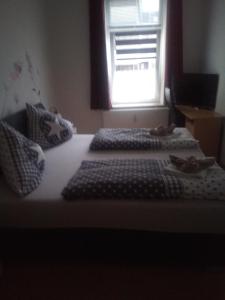 2 Betten in einem Zimmer mit Fenster in der Unterkunft Boardinghouse Wilhelmshaven in Wilhelmshaven
