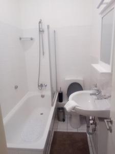 ein weißes Badezimmer mit einer Badewanne und einem Waschbecken in der Unterkunft Boardinghouse Wilhelmshaven in Wilhelmshaven