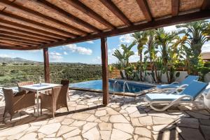 a patio with a table and chairs and a pool at Villa Thea in Peyia