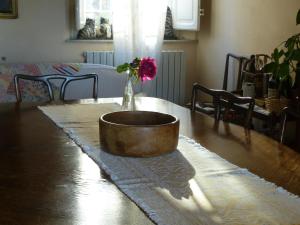 una mesa de madera con un jarrón con una flor. en Casa Marcè a "Sonno", en Porcari