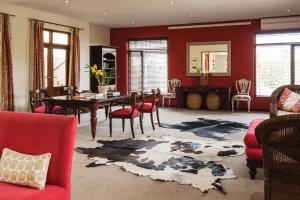 a dining room with red walls and a table and chairs at Casterbridge Hollow Boutique Hotel in White River