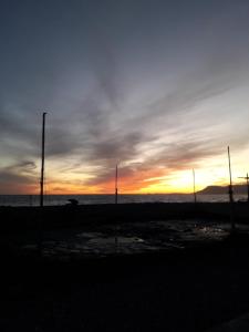 a sunset on the beach with poles in the foreground at Carso 10 in Ventimiglia
