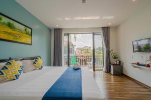 um quarto com uma cama grande e uma parede azul em Golden Star Villa Hoi An em Hoi An
