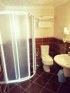 uma casa de banho com um chuveiro, um WC e um lavatório. em Grand Didyma Hotel em Didim