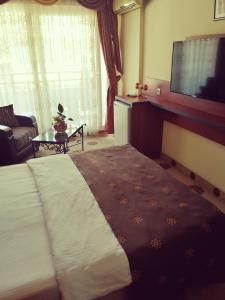 um quarto de hotel com uma cama e uma televisão de ecrã plano em Grand Didyma Hotel em Didim