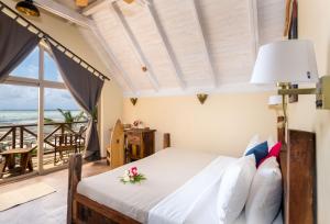 a bedroom with a bed with a view of the ocean at Clove Island Villas & Spa in Makunduchi