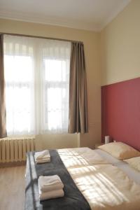 1 dormitorio con 1 cama con 2 toallas en Piros Arany Panzió Kalocsa, en Kalocsa