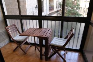 Una mesa de madera y dos sillas en un balcón. en Plaza Monterrey parking opcional by Salamancavacacional, en Salamanca