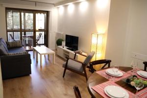 Una sala de estar con una mesa y una sala de estar con un sofá. en Plaza Monterrey parking opcional by Salamancavacacional, en Salamanca