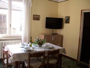ein Esszimmer mit einem Tisch und einem TV in der Unterkunft appartamento alpini in Cannero Riviera
