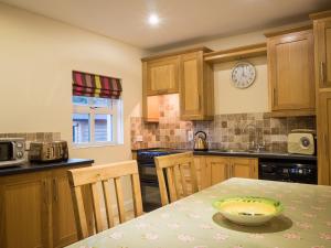 a kitchen with a table and a clock on the wall at The Apartment at Mullans Bay in Kesh