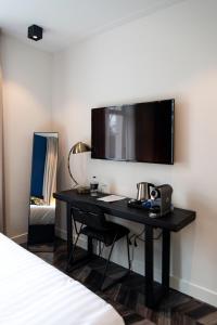 a hotel room with a desk and a television at WesterVilla in Amsterdam