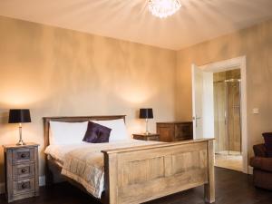 a bedroom with a bed and a chandelier at The Willows at Mullans Bay in Kesh
