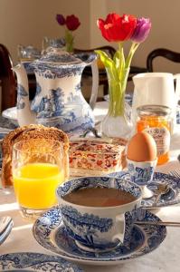 a table with blue and white vases and a cup of coffee at Sissinghurst Castle Farmhouse in Sissinghurst