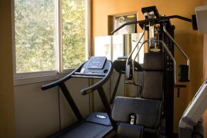 a room with a treadmill and a desk with a laptop at Hotel Dei Platani in Rimini