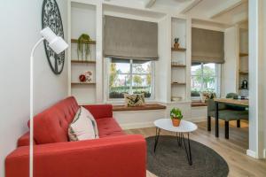 ein Wohnzimmer mit einem roten Sofa und einem Tisch in der Unterkunft De Herberg Appartementen in Renesse