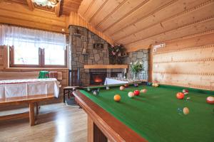a pool table in a room with a fireplace at Smrekowe Izby in Leśnica