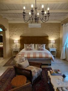 a bedroom with a large bed and a chandelier at Hartland Garden Suite in Oudtshoorn