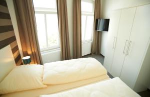 a bedroom with two white beds and a window at Apartment Eisberg 6 mit Balkon in Norderney