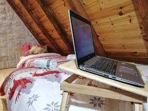 un computer portatile seduto su un tavolo su un letto di Apartmani RUNOLIST a Žabljak