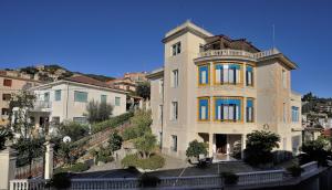 ヴァラッツェにあるHotel Villa Centaの黄色と青の窓が特徴の大きな建物