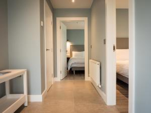 a hallway with a bedroom and a bed in a room at Platinum Lakeside Lodge at Mullans Bay in Kesh