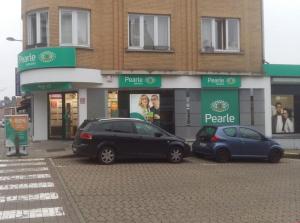 two cars parked in a parking lot in front of a store at Le dernier métro in Brussels