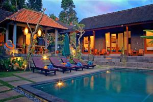 a villa with a swimming pool in front of a house at Villa Kicen Ubud in Ubud