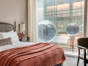 a bedroom with a bed and a window with bubbles at The Stratford Hotel London in London