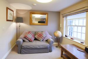 a living room with a couch and a mirror at Host & Stay - Spyglass 1708 in Whitby