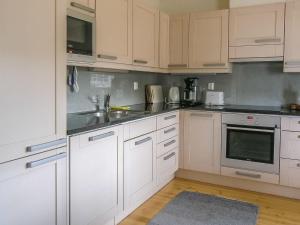 une cuisine avec des armoires blanches et des appareils en acier inoxydable dans l'établissement Holiday Home Suvela by Interhome, à Kukkola
