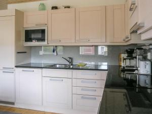 - une cuisine avec des placards blancs et un évier dans l'établissement Holiday Home Suvela by Interhome, à Kukkola