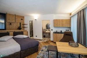 a bedroom with a bed and a table and a kitchen at Dolce vita #Cà Rossa in Sondrio